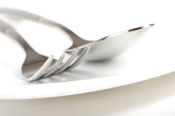 Photo of fork and spoon on plate.