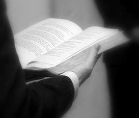 Priest holding a bible. Close up in black and white
