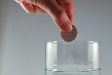 Hand dropping tablet in water