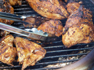 bar-b-que chicken on the grill with tongs