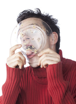 jeune homme pull rouge relechant assiette