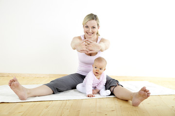 junge mama macht mit ihrem baby fitness + yoga uebungen