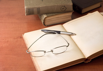 opened book, pen and glasses