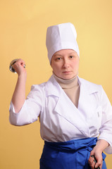Portrait of young cook playing with her spoon.