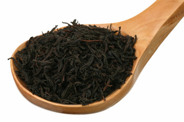 Tea in a wooden spoon on a white background