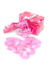 beautiful wrapped gift with rose leaves in heart shape