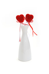 Two red plush hearts in white vase