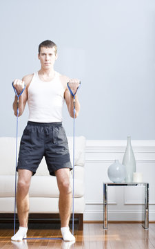 Man Using Resistance Bands In Living Room