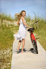 Fototapeta na wymiar Girl Walking Bike on Boardwalk.