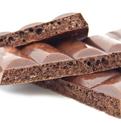 Some slices of black porous chocolate on a white background