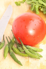 Cutting board with coriander, tomato and green chili