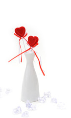 Two red plush hearts in white vase