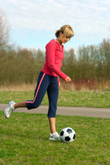 Sportswoman Kicking a Ball