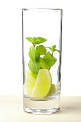 Mojito mix: lime, mint in glass on wood table