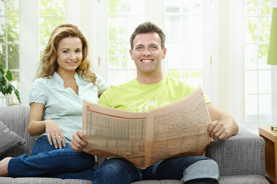 Happy couple reading news