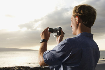 Man Using Video Camera at the Beach