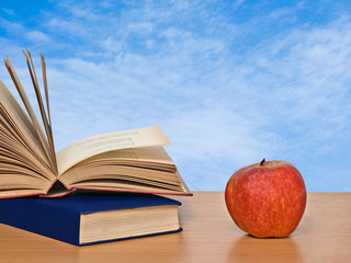 Red apple and books on desk