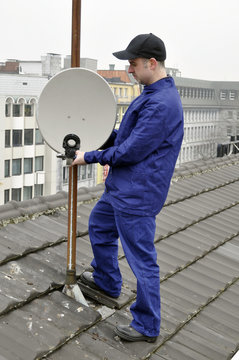 TV-Mechaniker montiert Sat-Sch&uuml;ssel