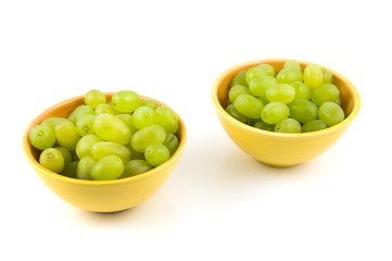 Fresh green grapes in yellow bowls