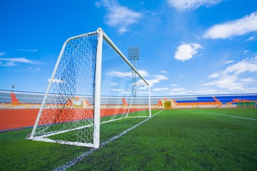 STADIUM - Football field with goal and tablo on blue sky