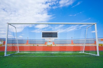 Fototapeta premium STADIUM - Football field with goal and tablo on blue sky