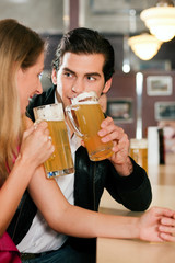 Couple in bar drinking beer flirting