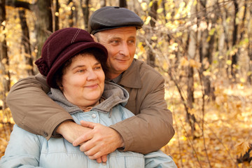 Fototapeta premium Old man embrace old woman in autumnal forest