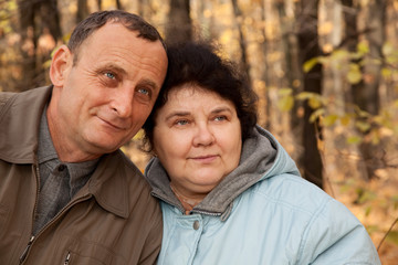 Fototapeta premium Old man and old woman walk in autumnal forest