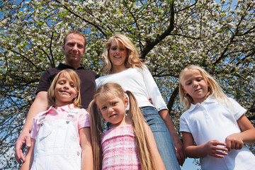 Fototapeta premium Familie unter einem Apfelbaum im Frühling