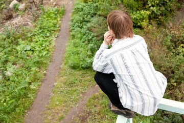 man guy is sitting on the bridge edge