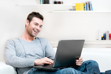 Smiling young man working on laptop