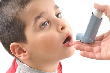 Close up image of a cute little boy using inhaler for asthma