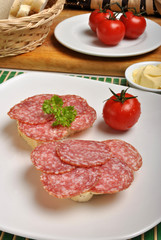 slice poppy seed bread with salami on a plate