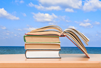 Open book on desk and sea