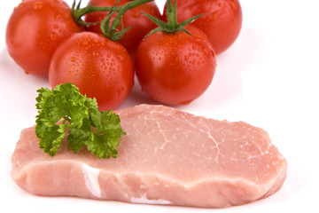 Rohes Stück Fleisch mit Tomaten isoliert