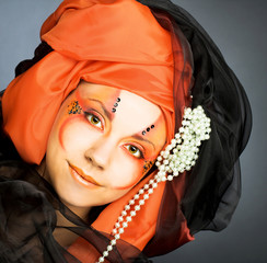 Young woman in black and orange turban