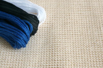 Embroidery threads on a beige canvas
