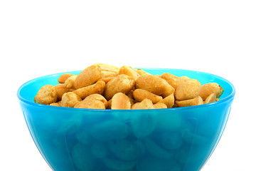 Blue bowl with salted peanuts over white background