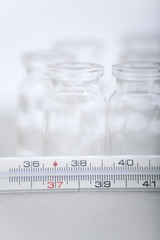 Thermometer and bottles of pills