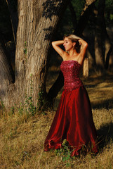 Portrait of the beautiful blonde with long hair in red dress