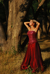 Portrait of the beautiful blonde with long hair in red dress