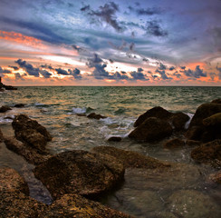 Stitched Panorama. Tropical sunset on the stones beach.Thailand