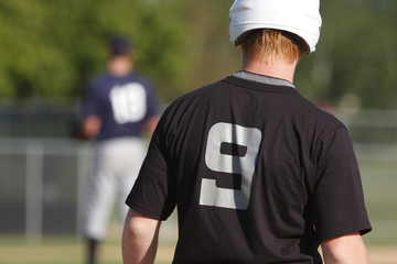 Runner on first base watching the pitcher.