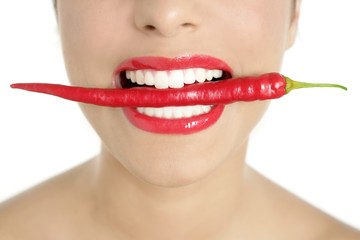 Beautiful woman teeth eating red pepper