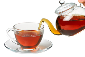 Black tea pouring in cup from teapot