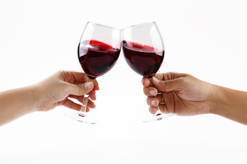 Two people toasting with wine glasses filled with red wine