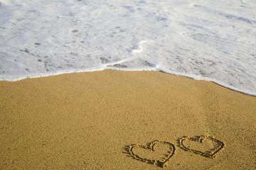Zwei Herzen auf Strand im Urlaub