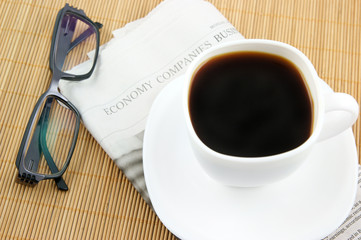 Coffee cup with glasses and newspaper