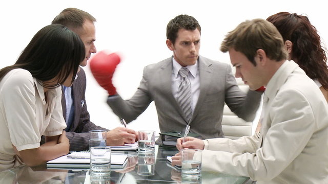 Angry manager hitting his team with boxing gloves in the office