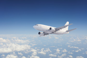 Fototapeta premium Samolot na niebie, nad chmurnym niebem